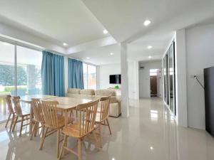 a dining room and living room with a table and chairs at Sealife4 Beach Pool Villa in Rayong