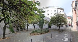 a city street with trees and a white building at Le petit Berriat - Grenoble centre in Grenoble