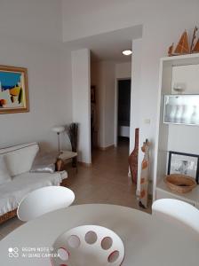 uma sala de estar com um sofá e uma mesa em Ombre et soleil vue sur la lagune et bateaux em Saint-Cyprien
