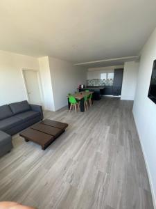 een woonkamer met een bank en een tafel bij Charmant appartement près de EPFL UNIL Lausanne in Renens