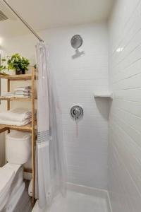 a white bathroom with a shower and a toilet at Luxury Studio Apt in Lake Merritt in Oakland