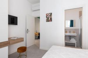 een witte slaapkamer met een bed en een badkamer bij Nimar Suite in Formia