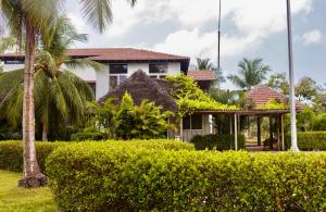 MandapamJoe's Beach Shack - Beach resort, Ramanathapuram的棕榈树和灌木丛的房子