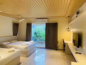MandapamJoe's Beach Shack - Beach resort, Ramanathapuram的有两张床和一扇窗户的酒店房间