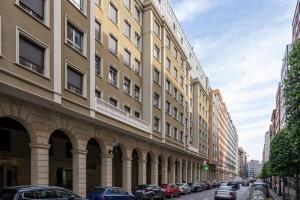 a city street with cars parked next to a tall building at Apartamento Massastur in Gijón