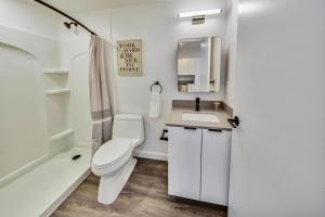 Baño blanco con aseo y lavamanos en Stylish Studio in Laney-Peralta en Oakland