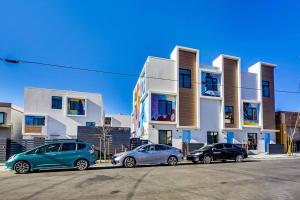 een groep van drie auto's geparkeerd voor een gebouw bij Stylish Studio in Laney-Peralta in Oakland