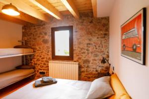 ein Schlafzimmer mit einem Bett und einer Ziegelwand in der Unterkunft Preciosa casa rural Cal Jaumet in Cava