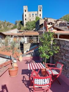 a patio with red chairs and a table and a castle at BB Le Gemme in Dolceacqua