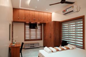 a bedroom with a bed and a desk and a window at Kalloos Island Backwater Resort in Kollam