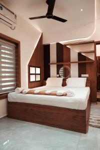 - une chambre avec un grand lit et un ventilateur de plafond dans l'établissement Kalloos Island Backwater Resort, à Kollam