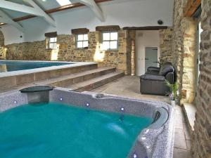 una grande piscina in un edificio con una grande vasca di Heartwell Cottage a Wolsingham