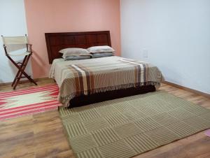 a bedroom with a bed and a rug on the floor at Solar dos Reis - Apartamento Turmalina in Ouro Preto