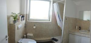 a bathroom with a toilet and a sink and a window at Ferienwohnung in Kronshagen Monteurwohnung 3 Zimmer 70 m2, Küche und Badezimmer in Kronshagen