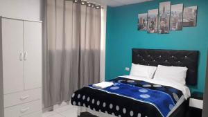 Dormitorio azul con cama y pared azul en HOSPEDAJE BLESS, en Trujillo