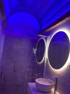 een badkamer met een wastafel en 2 ronde spiegels bij Zahra Superior Suite with private pool in Sannicola
