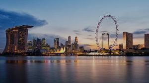 a city skyline with a ferris wheel in the water at 1Bedroom apartment near Orchard Rd! in Singapore