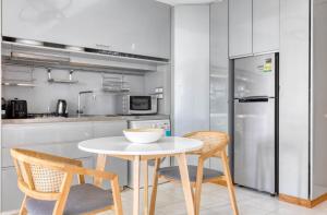 a kitchen with a table and two chairs and a refrigerator at 1Bedroom apartment near Orchard Rd! in Singapore