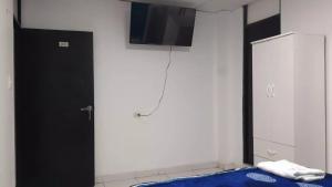 um quarto com uma porta preta e uma televisão na parede em HOSPEDAJE BLESS em Trujillo