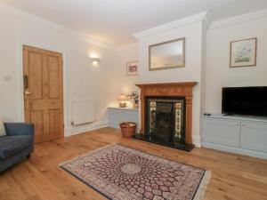 a living room with a fireplace and a tv at Thyme Cottage in Great Malvern