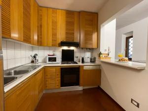 uma cozinha com armários de madeira e um forno com placa de fogão em At the Boboli Garden Carola Loft em Florença