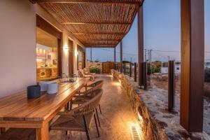a dining room with a long wooden table and chairs at Sia Elafonisi Pool House in Elafonisi