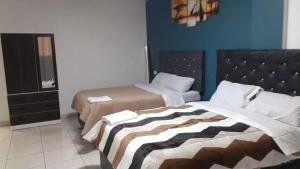 a bedroom with two beds and a blue wall at HOSPEDAJE BLESS in Trujillo