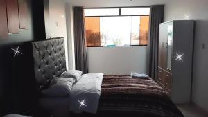 a bedroom with a bed and a window at HOSPEDAJE BLESS in Trujillo