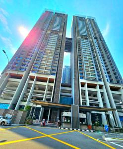 two tall buildings with a parking lot in front of them at Atlantis Residence Melaka By GGM in Melaka