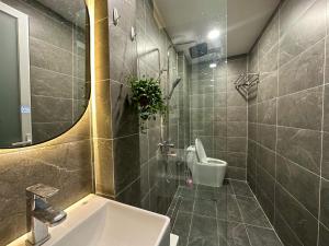 een badkamer met een wastafel, een toilet en een spiegel bij Phạm Viết Chánh-SSHOMES -1 PHÒNG NGỦ RIÊNG in Ho Chi Minh-stad