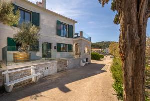 una casa con finestre in vetro e un albero di Villa Mare Vista a Žman