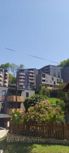 une clôture avec des fleurs devant certains bâtiments dans l'établissement Mavrov02 Residence, à Mavrovo