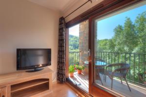 a living room with a large window and a tv at Apartaments Flor De Neu in Sarroqueta