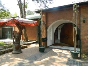 a patio with an umbrella next to a brick building at The Landmark Boutique Hotel in Blantyre