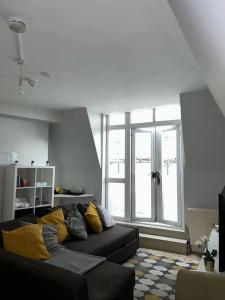 a living room with a couch and a large window at 1 Bed apartment with a balcony in London