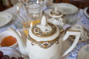 biały imbryczek siedzący na stole z naczyniami w obiekcie Arte Bianca w mieście Palermo