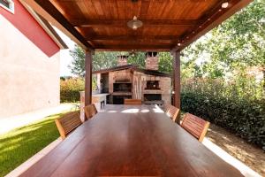 an outdoor patio with a wooden table and chairs at Villa Luxury - Sarzana in Luni