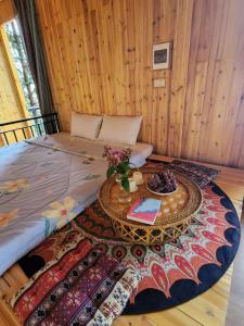 a bedroom with a bed with a table on a rug at THEN'S HOUSE Y TÝ in Phan Kơng Su