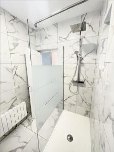 baño blanco con ducha y lavamanos en Le Golf Sauna - Cosy & SPA - 1 chambre - 2 pers, en Saint-Étienne