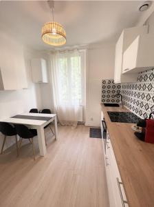 cocina y comedor con mesa y sillas en Le Golf Sauna - Cosy & SPA - 1 chambre - 2 pers, en Saint-Étienne