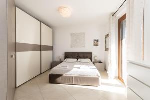 a white bedroom with a bed and a window at Villa Luxury - Sarzana in Luni