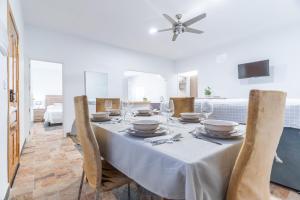 a dining room with a white table with chairs at Casa rural Acueducto in Almería