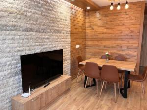 a dining room with a table and a large television at Alpine luxury two bed-two bathrooms apartment B25 in Borovets