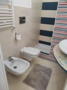 La salle de bains est pourvue de toilettes blanches et d'un lavabo. dans l'établissement KiMia Home, Centro, à Modugno