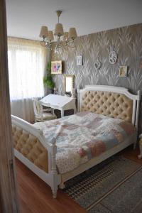 a bedroom with a large bed and a table at Provence apartment in Šiauliai