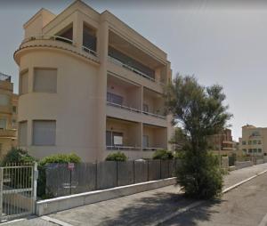 een gebouw met een hek ervoor bij Alma Ùnica Fronte Mare in Lido di Ostia