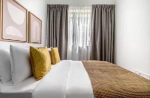 新加坡的住宿－2Bedroom apartment near Orchard RD!，卧室配有一张带黄色枕头的大型白色床。
