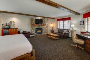 a bedroom with a bed and a living room with a fireplace at Stoney Creek Hotel Peoria in Peoria