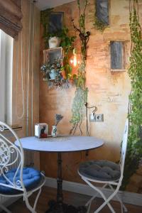 une table et deux chaises avec des plantes sur le mur dans l'établissement Provence apartment, à Šiauliai