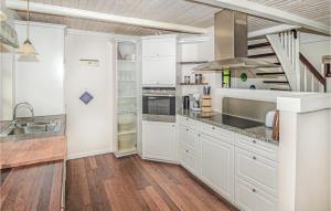 una cucina con armadietti bianchi e una scala di 5 Bedroom Stunning Home In Stakroge a Knaplund